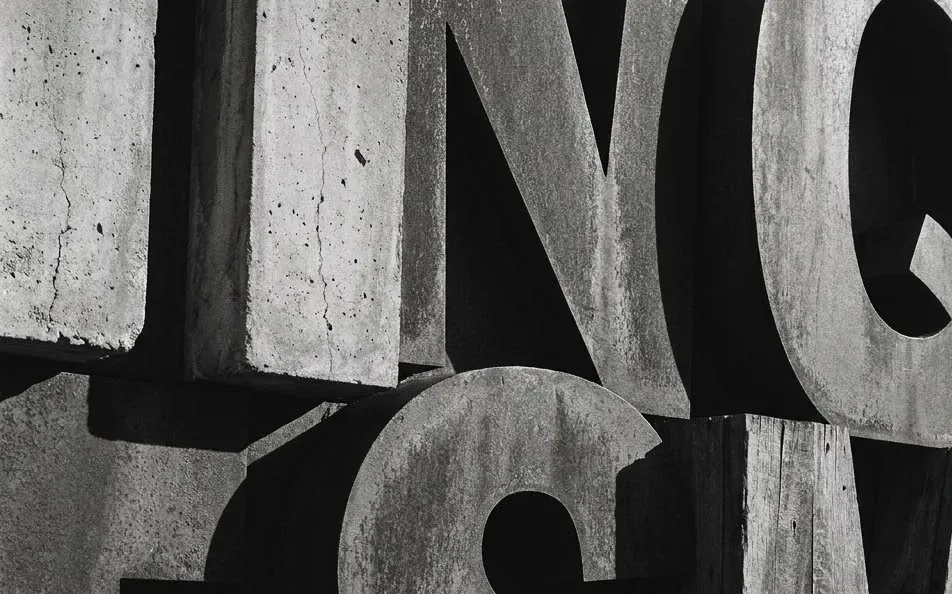 Large weathered letterpress blocks stacked in the dark